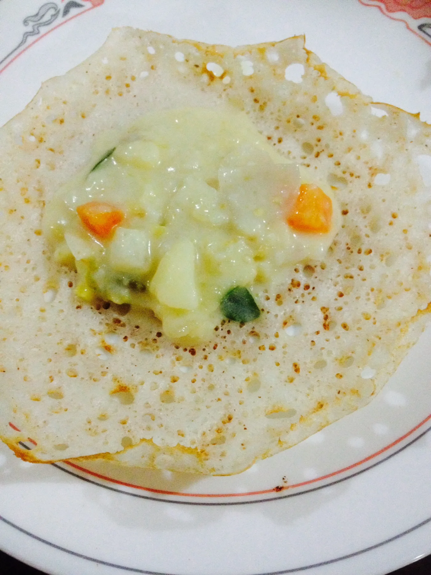 Palappam with vegetable stew spooned into the soft centre.