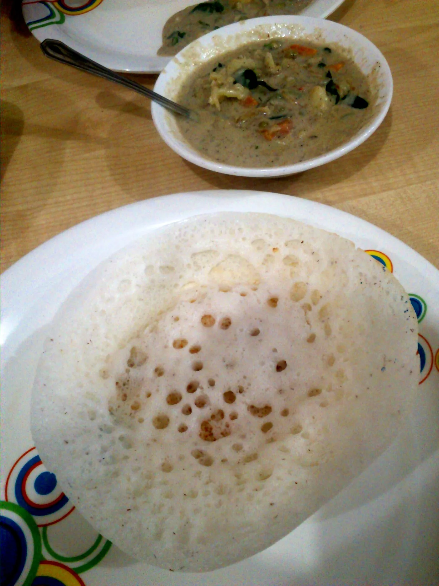 Lacy appam with a bowl of coconut-milk vegetable stew.
