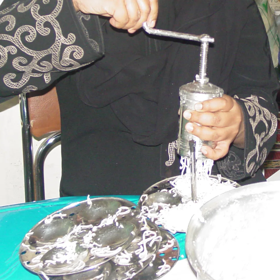Rice dough pressed into strings onto a steamer plate.